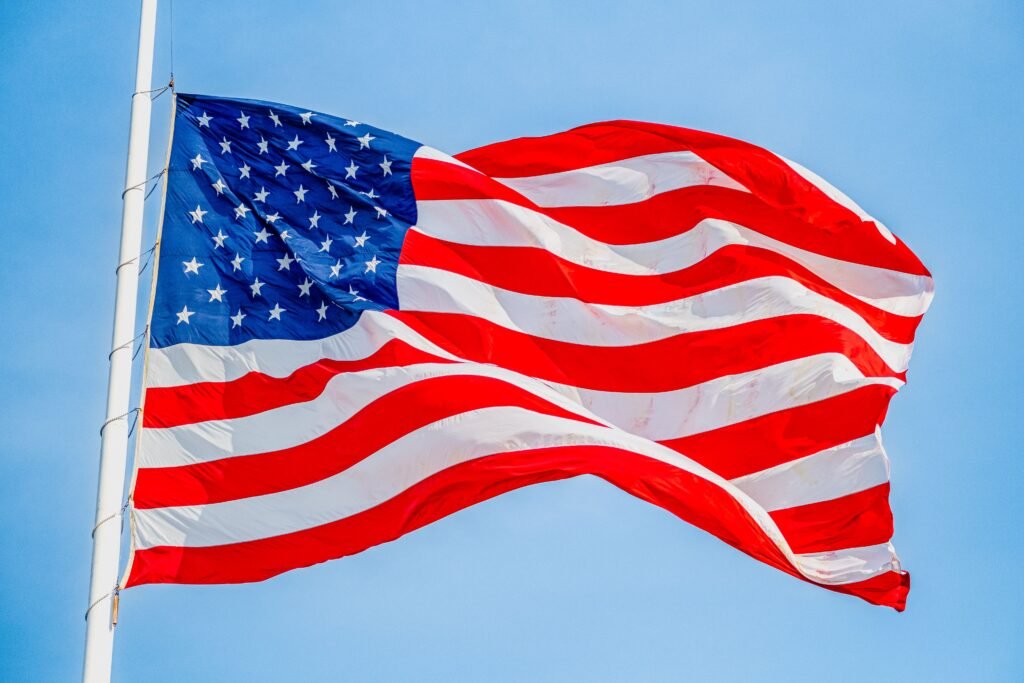 A detailed close-up photo of the USA flag waving on a bright, clear day.